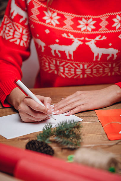 istock woman hands writing on christmas postcard 497801584