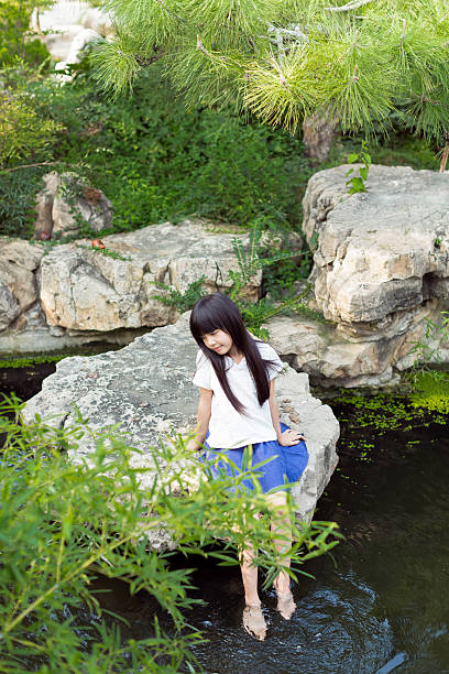 istock beautiful little girl playing in a pond 497803346
