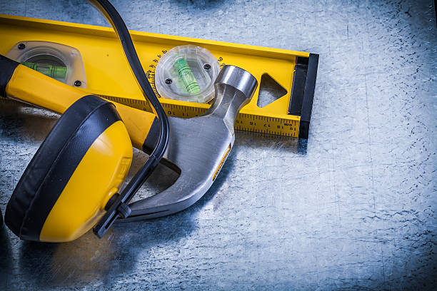 istock Earmuffs construction level claw hammer on scratched metallic ba 497804260