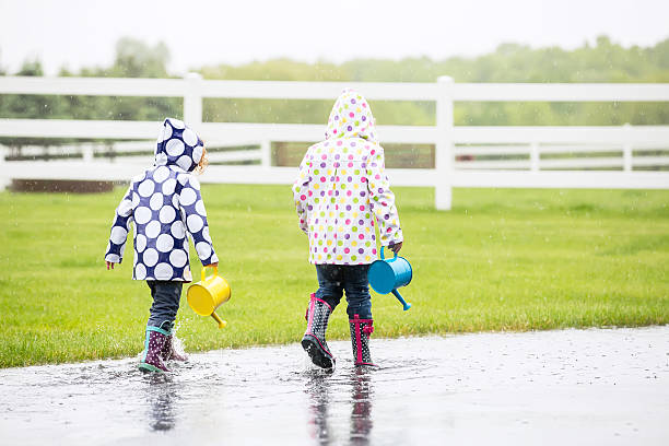 istock Two Young Girls Playing In Rain Puddle 497804570