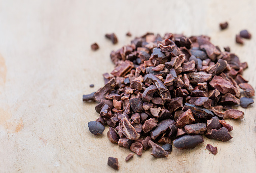 Processed cocoa nibs on the wooden surface