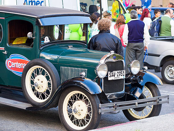Montevideo, Uruguay - January 25, 2013: A vintage car seen on the streets crowded with people during the 2013 Inaugural Parade of the Uruguayan carnival along Avenida 18 de Julio in Montevideo, Uruguay.