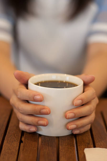 istock woman hand holding coffee mug on wood table 497811178