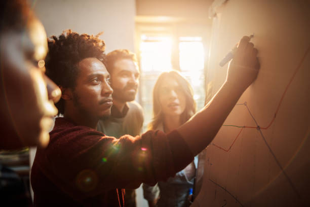 группа деловых людей, анализируя график в офисе. - решение проблемы стоковые фото и изображения