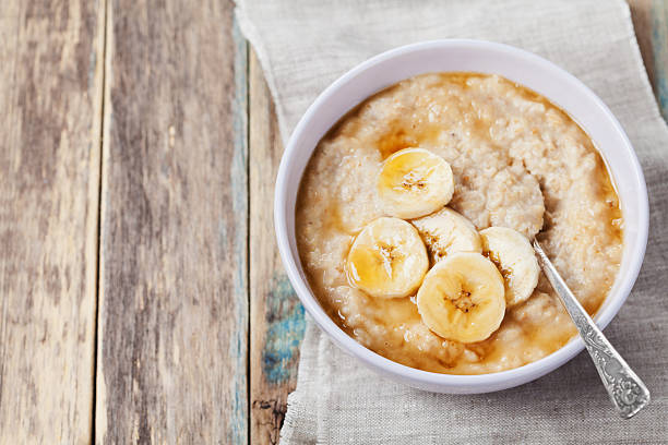 petit déjeuner équilibré, du porridge, du porridge et une banane avec espace de la copie de texte - flakes photos et images de collection