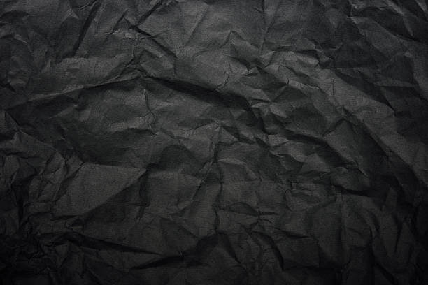 istock Crumpled black rice paper background with spotlight 497825842