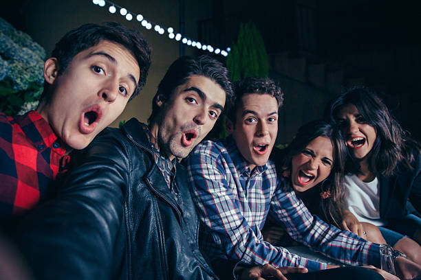 istock Funny friends shouting and taking selfie in party 497826240