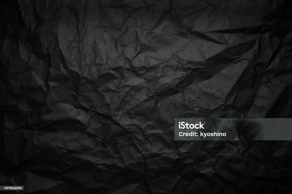 Crumpled black rice paper background with spotlight Close-up of crumpled black rice paper background with spotlight. Black Color Stock Photo