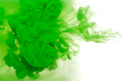 Abstract background of green acrylic paint in water. Studio photography on a white background.