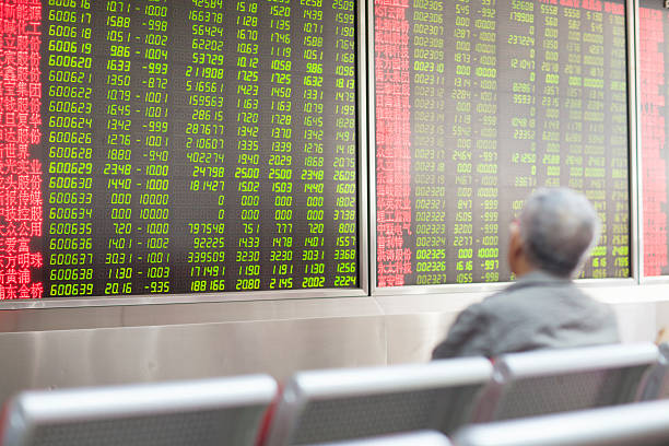 Chinese Citizens Watching Stock Market, Beijing 2015 Beijing, China - August 24, 2015: Chinese citizen watching stock information at a Beijing open-to-the-public municipal access market trading exchange room facility during a stock market index decline in China. ticker tape machine stock pictures, royalty-free photos & images