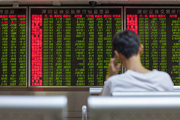 Chinese Citizens Watching Stock Market, Beijing 2015 Beijing, China - August 24, 2015: Chinese citizen watching stock information at a Beijing open-to-the-public municipal access market trading exchange room facility during a stock market index decline in China. ticker tape machine stock pictures, royalty-free photos & images