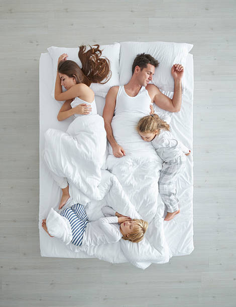 famiglia a letto - couple affectionate relaxation high angle view foto e immagini stock