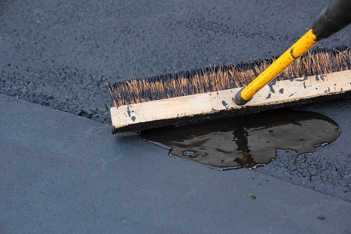 Asphalt Blacktop Driveway sealing paving with brush