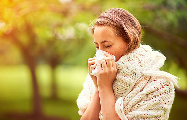 It's allergy season... Shot of a young woman blowing her nose outsidehttp://195.154.178.81/DATA/i_collage/pi/shoots/805934.jpg hayfever stock pictures, royalty-free photos & images