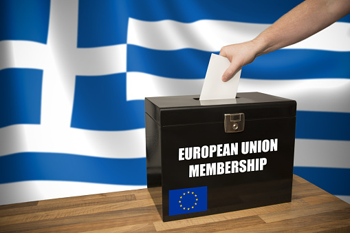 A hand casting a vote in a black ballot box for an election in Greece - EU Referendum