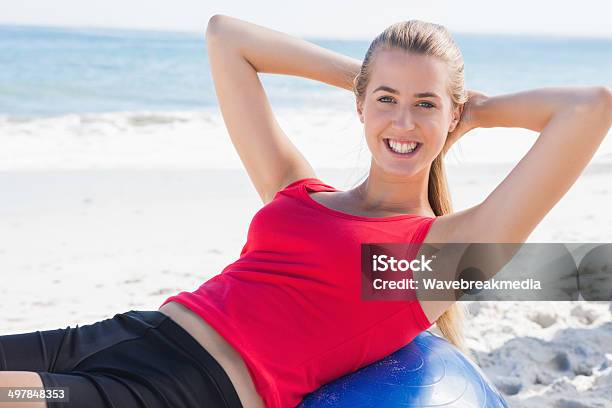Fit Blonde Doing Sit Ups On Exercise Ball Stock Photo - Download Image Now - 20-29 Years, Abdomen, Abdominal Muscle