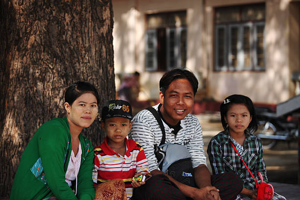 молодых бирманский семья, отдыхая в тени дерева. - bagan myanmar burmese culture family стоковые фото и изображения