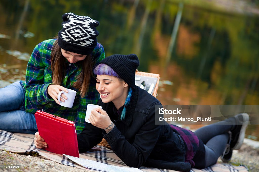 Two beautiful girl, relax in the mountain Two beautiful girl, relax in the mountain, play with tablet and drink some coffee 2015 Stock Photo