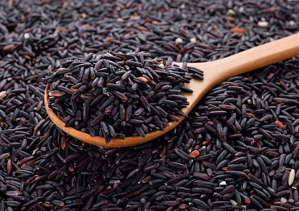 istock black rice in wooden spoon 497856448