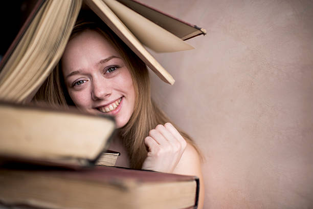 Young happy woman with a book on the head.