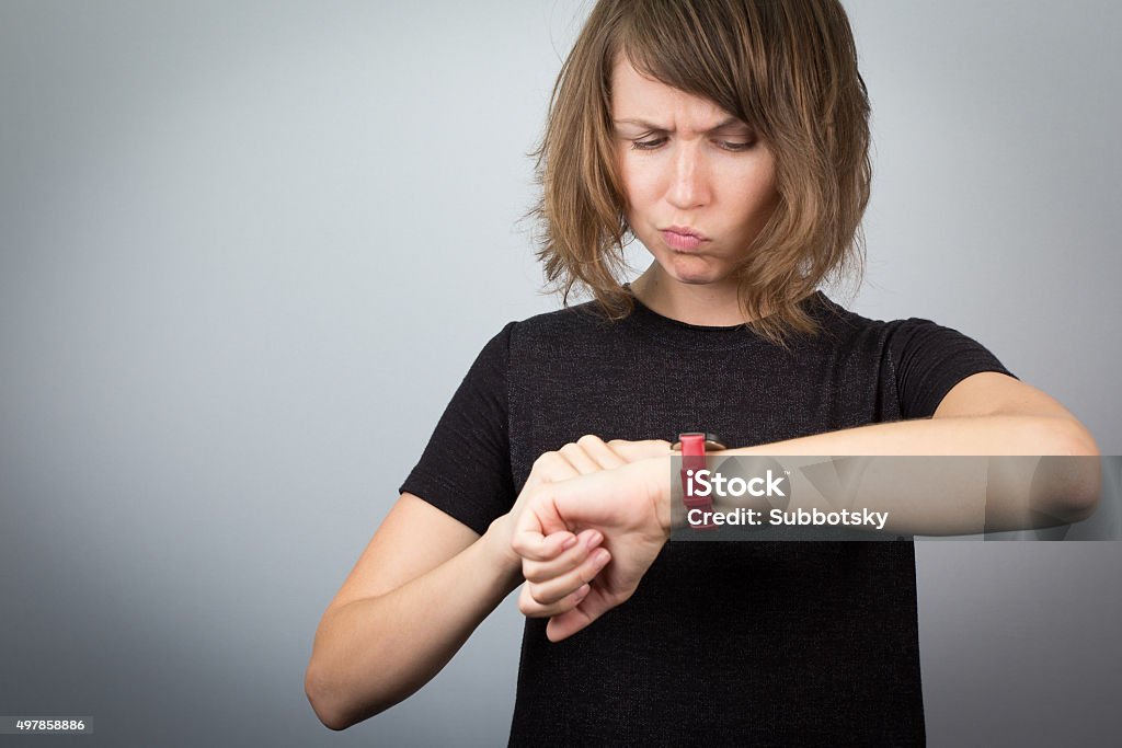 Young woman looking watch time waitnig. Young beautiful woman model studio looking watch clock time waiting angry expression. 2015 Stock Photo