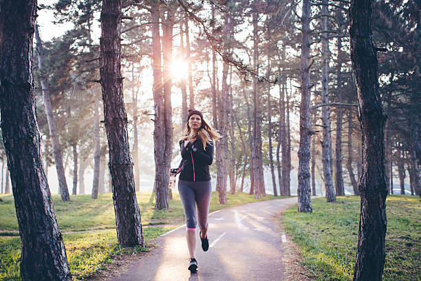 donna in esecuzione nella foresta - jogging autumn young women women foto e immagini stock