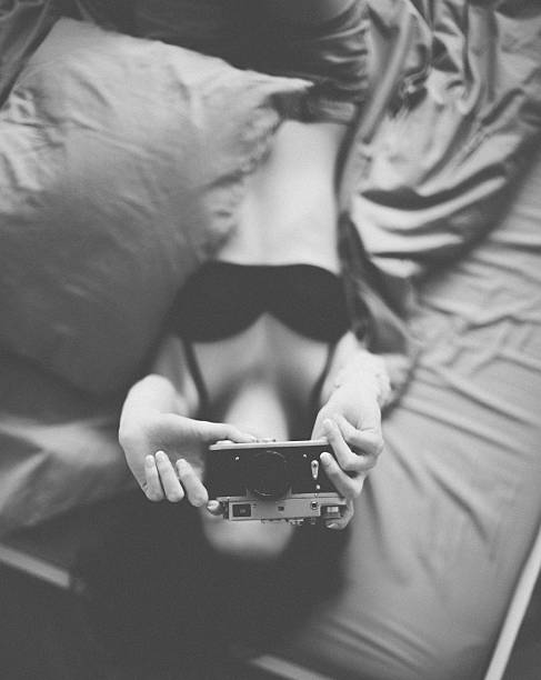 istock Girl in bed taking a photo 497858948