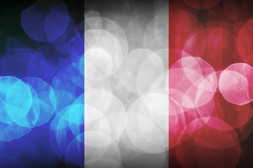 Horizontal composition full frame of french flag colors, blue, white and red, vibrant colors and dark with bokeh circle texture, photographic effect. Background for design with large copy space.