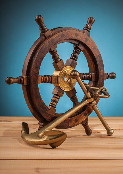 istock maritime adventure old anchor and old steering wheel 497859580