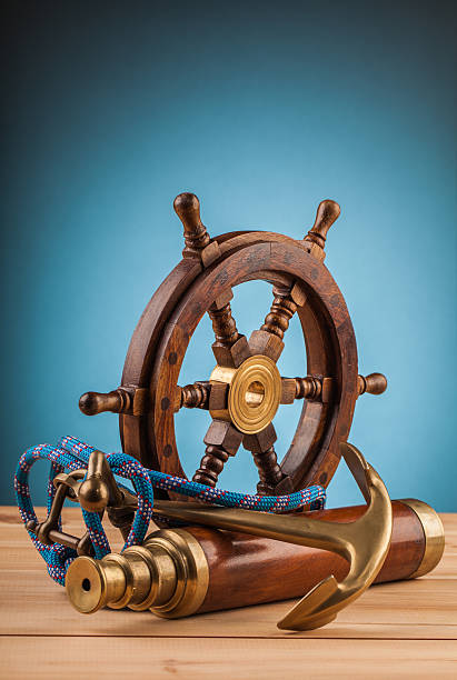 istock maritime adventure old anchor wheel  and old telescope 497860236