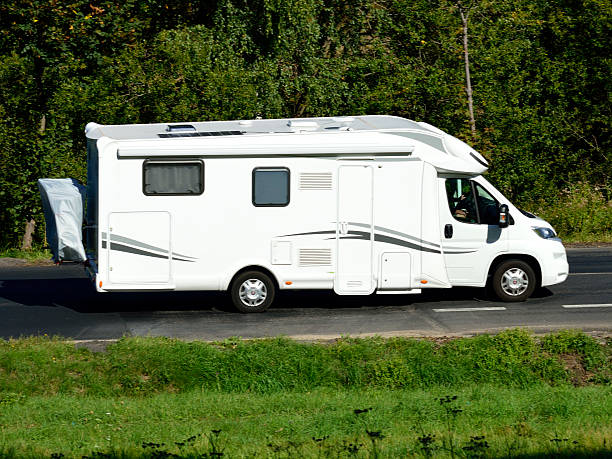 a white camper van is driving down the road