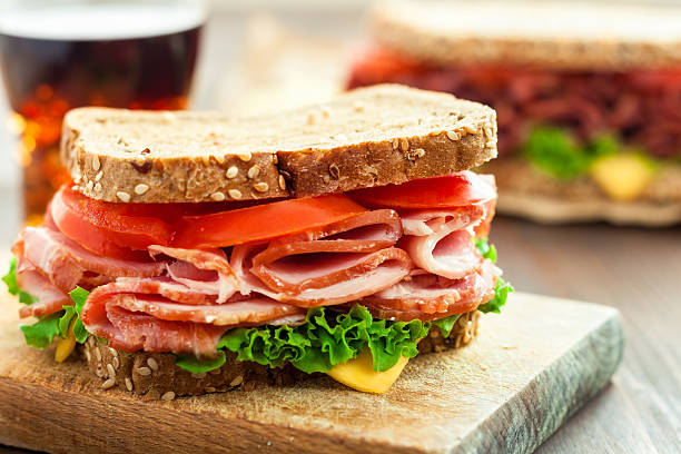 Ham and Cheese Sandwich Delicious sandwich with cheese, tomatoes, ham and salad delicatessen stock pictures, royalty-free photos & images