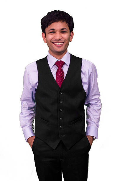 Young professional man smiling while hands in pockets.