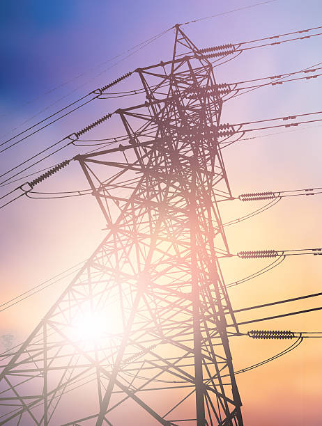 istock silhouette high voltage post.High-voltage tower over blur sky ba 497892314