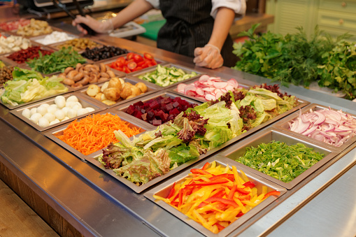 Salad bar with various fresh vegetables and other foods