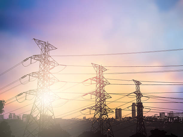 istock silhouette high voltage post.High-voltage tower over blur sky ba 497892588