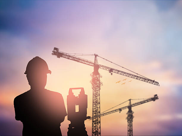 silhouette survey engineer working  in a building site over Blur silhouette survey engineer working  in a building site over Blurred construction worker on construction site civilian stock pictures, royalty-free photos & images
