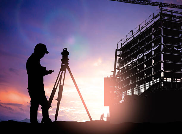 istock silhouette survey engineer working  in a building site over Blur 497893052