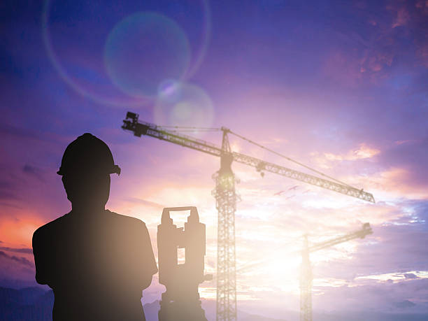 istock silhouette survey engineer working  in a building site over Blur 497893130