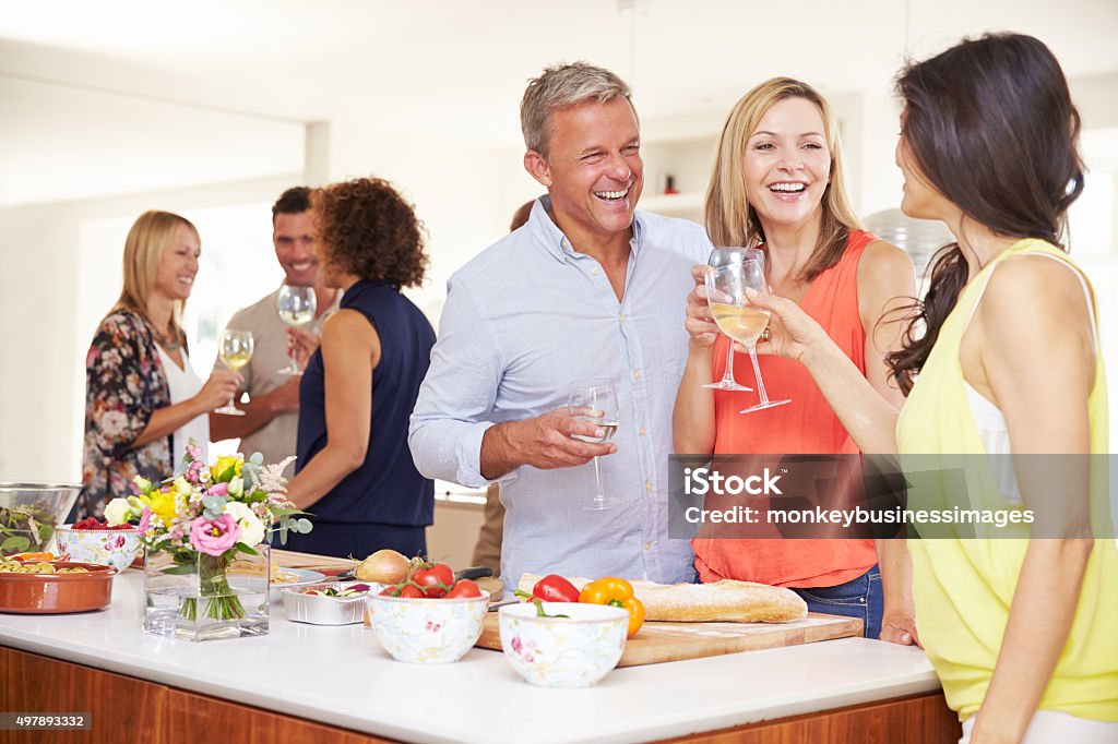 Mature Guests Being Welcomed At Dinner Party By Friends Dinner Party Stock Photo