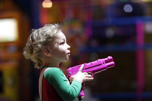 Portrait of toddler with pistol at indoor playground