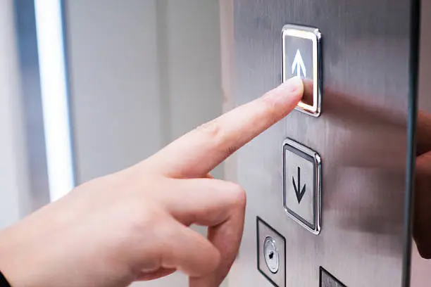 Hand pushing elevator button