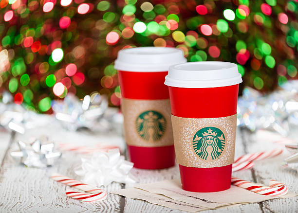 Starbucks holiday beverage Dallas, TX, USA - November 19, 2015: A cup of Starbucks popular holiday beverage, served in the new 2015 designed red holiday cup. Displayed with candy canes against sparkly holiday background. hot mix plant stock pictures, royalty-free photos & images