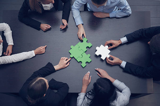 Business people assembling puzzle stock photo