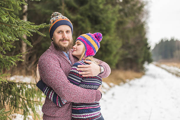 istock Young couple hugging in winter forest 497903118