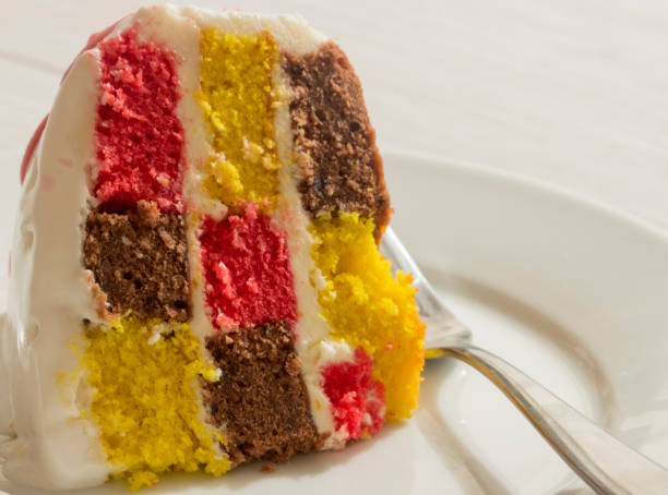 istock Slice of checkered cake on white plate with fork. 497903600