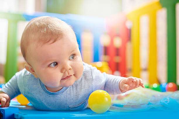 istock Young baby boy playing in his playpen doing tummy time 497905982