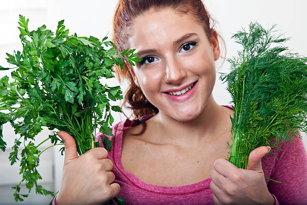 Beautiful woman eating parsley stock photo