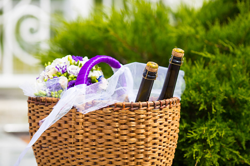 Wicker basket with two bottles champaign and flowers
