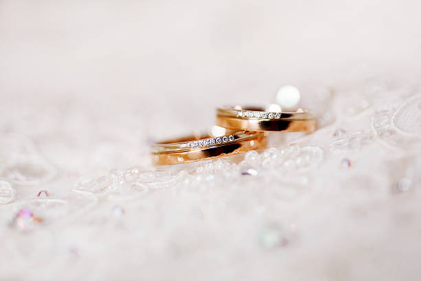 istock Golden wedding ringswith diamonds lie on lace silk fabric. 497935324